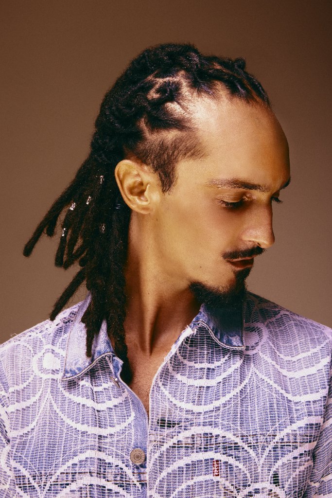 Homme de profil, tresses plaquées et locks ornées de perles