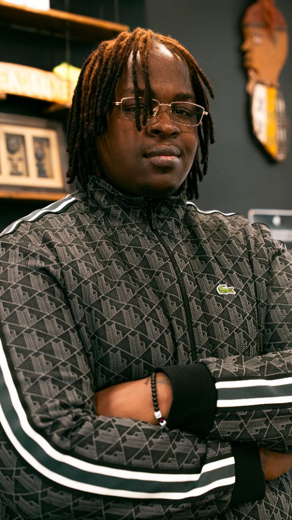 Coiffeur bras croisés dans le salon DreadLuxe